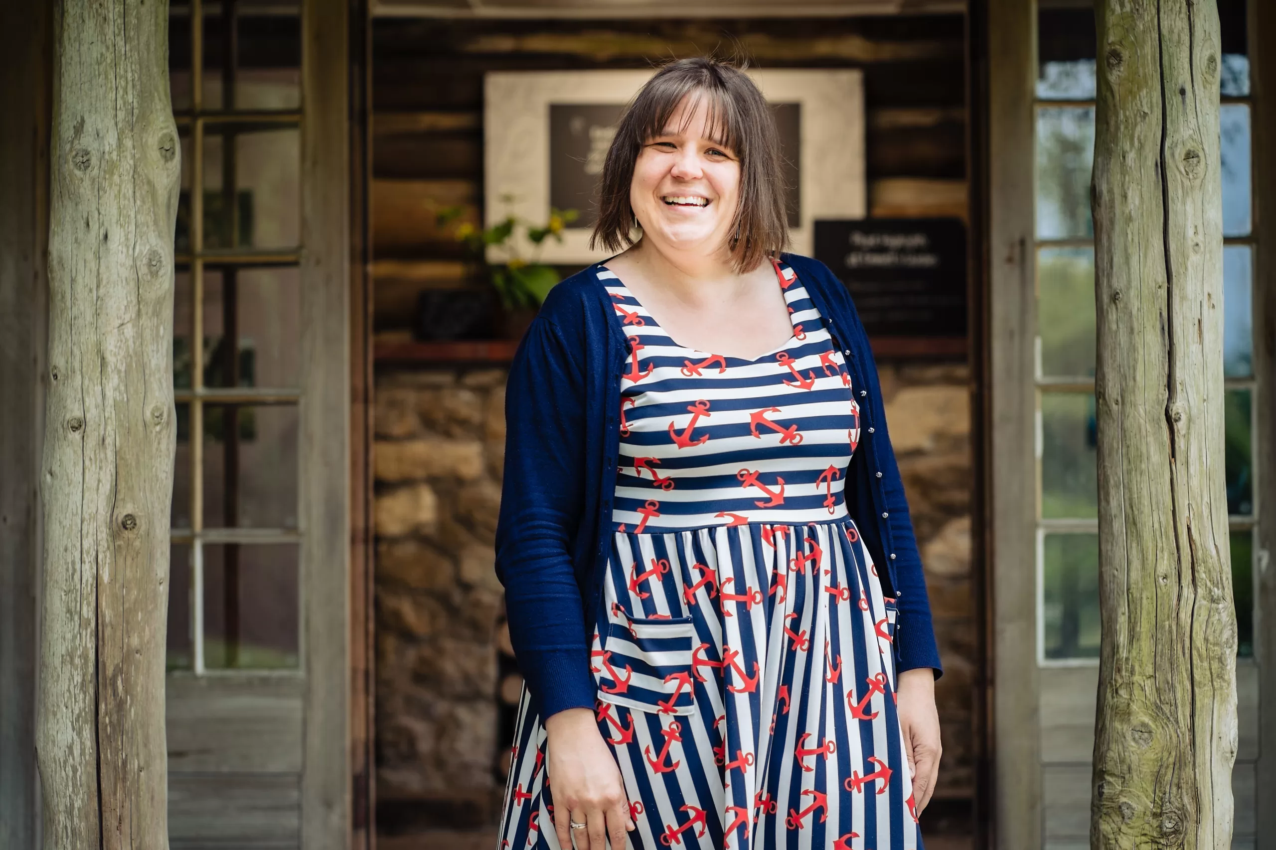 Steph standing in doorway of wooden cabin