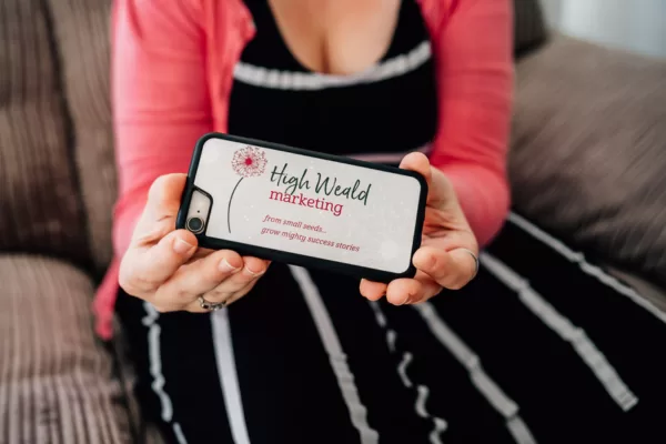 Hands holding high weald marketing phone