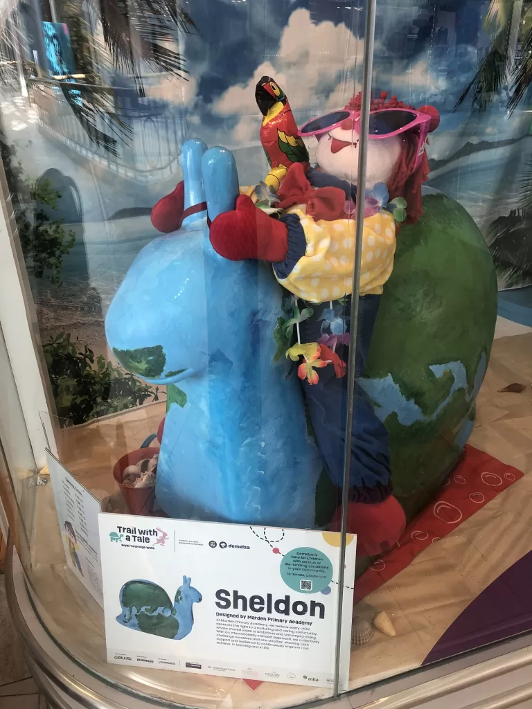 Gymbo the clown sitting on a sculpture of a snail